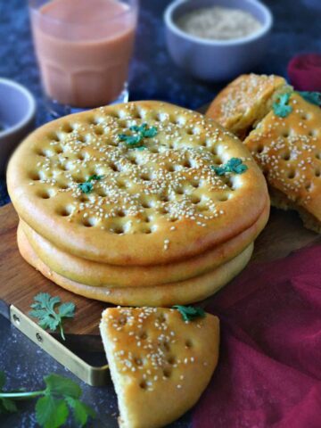 Stack of Roghni Naan on a wooden serving board