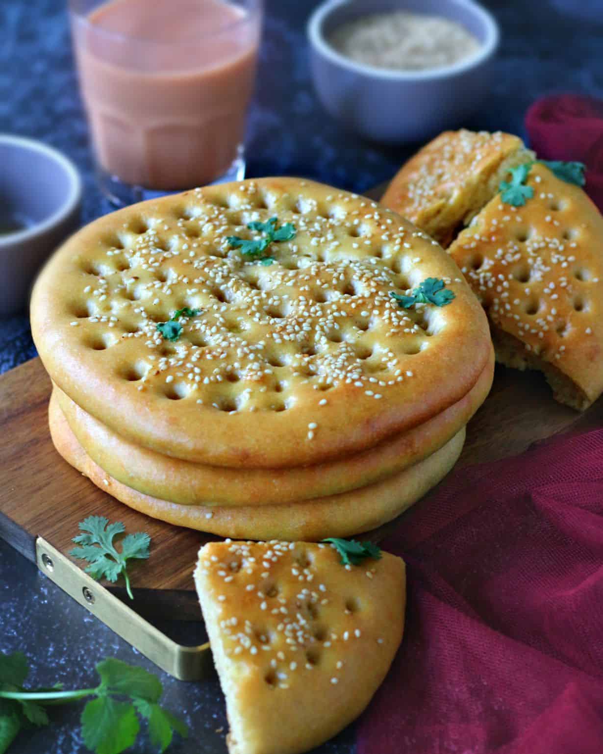 Stack of Roghni Naan on a wooden serving board