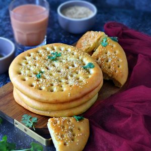 Stack of Roghni Naan on a wooden serving board