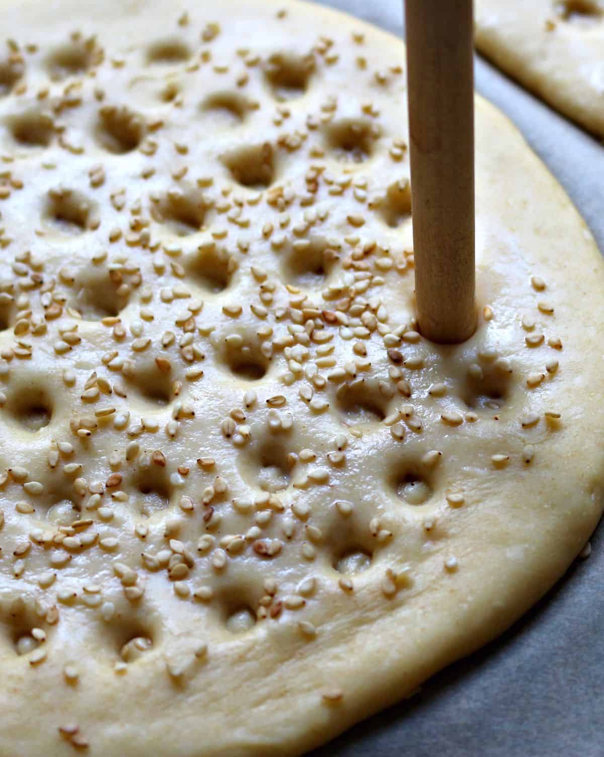 Making marks on Roghni Naan with a stick