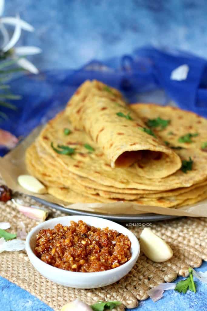 Spicy garlic chutney with a stack of besan ki roti in the back