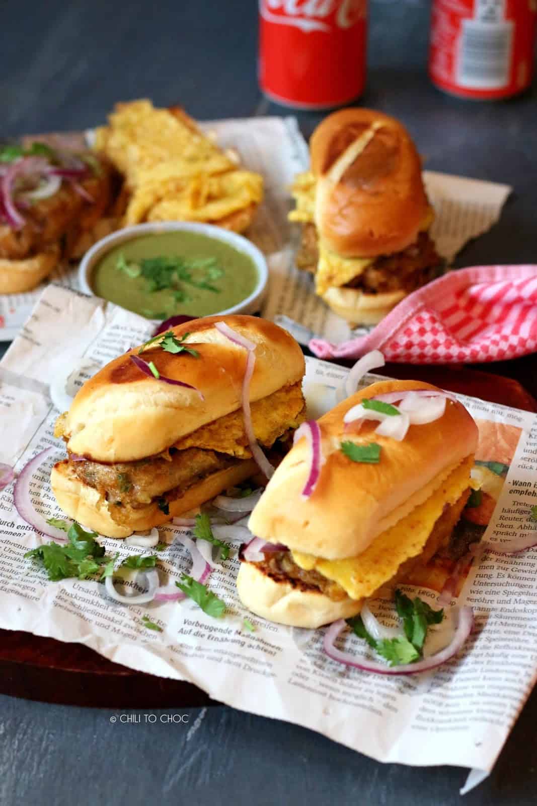 Pakistani Bun Kabab Bun Kababs with green chutney on a newspaper