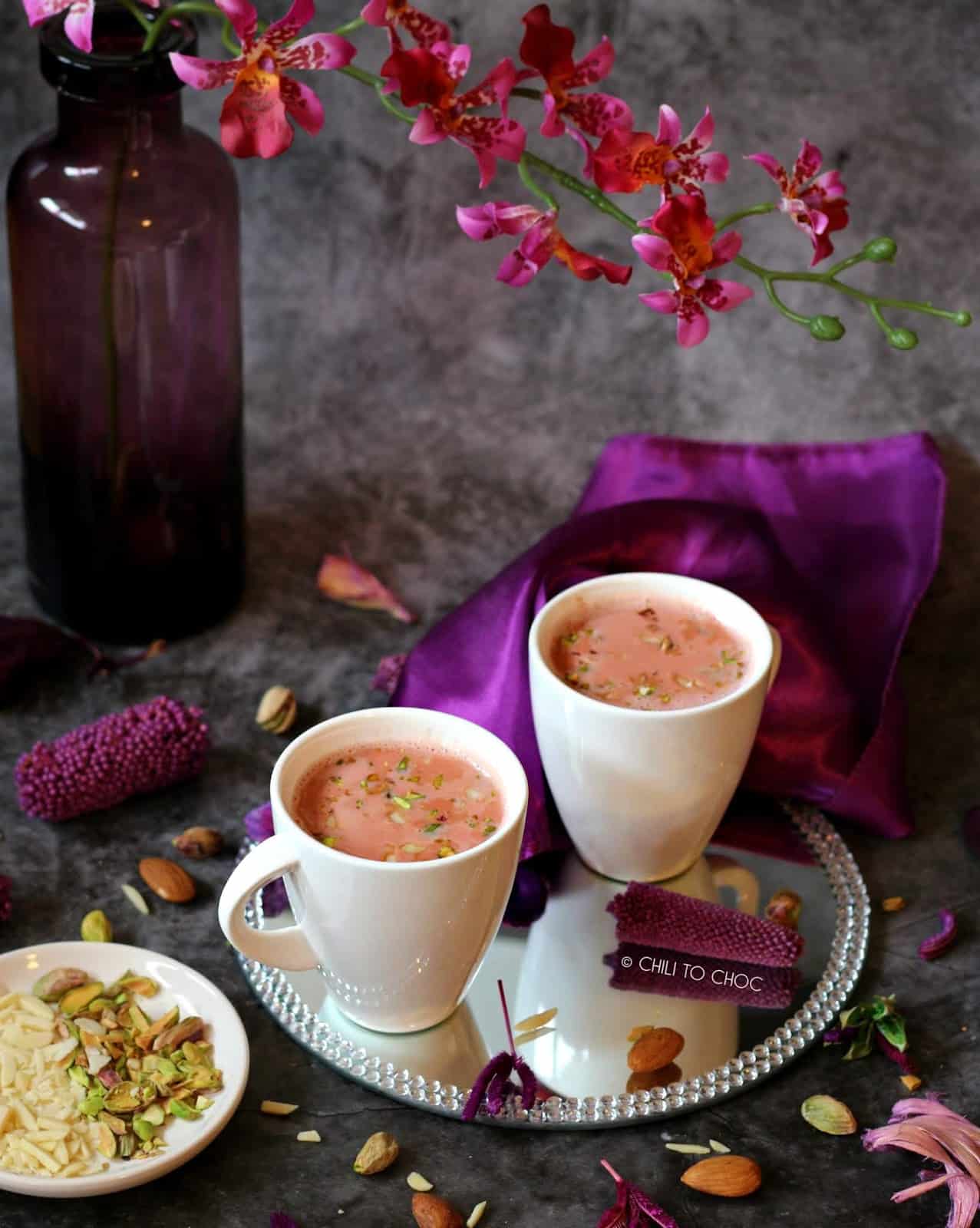 Two cups of Kashmiri Chai with decoration and garnish around it