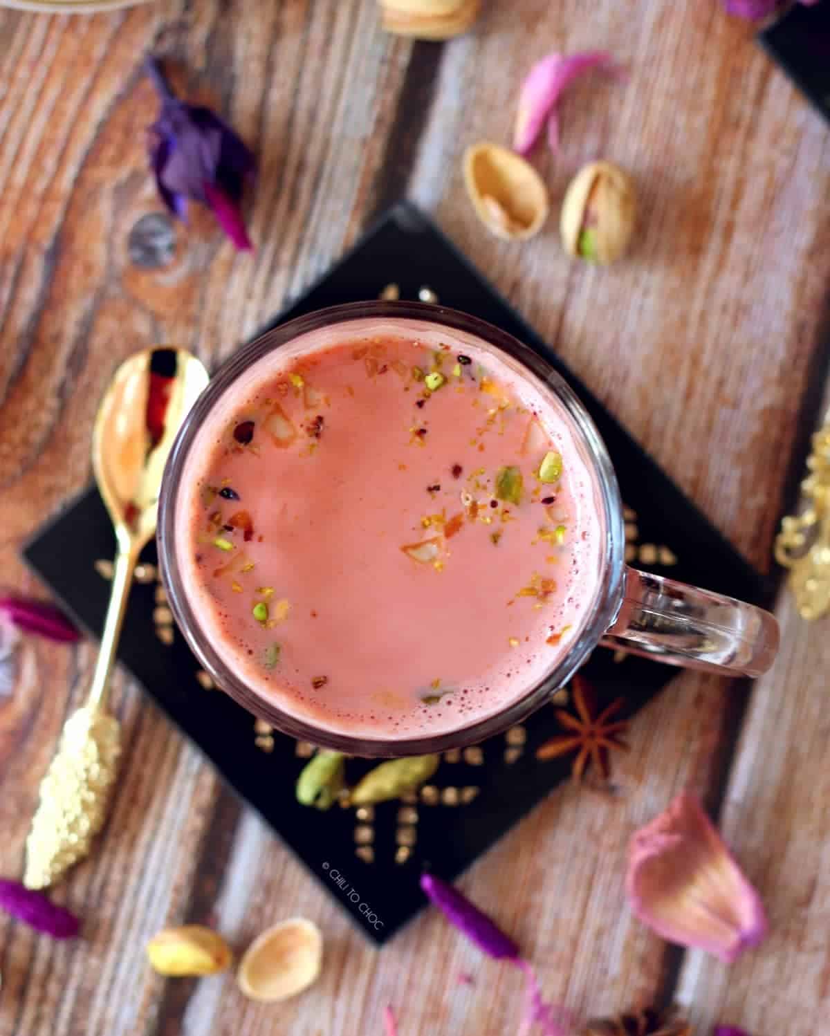 Top view of the pink tea with gold spoon on the side