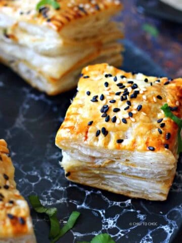 Pakistani chicken patties topped with sesame seeds on a marbled black tray