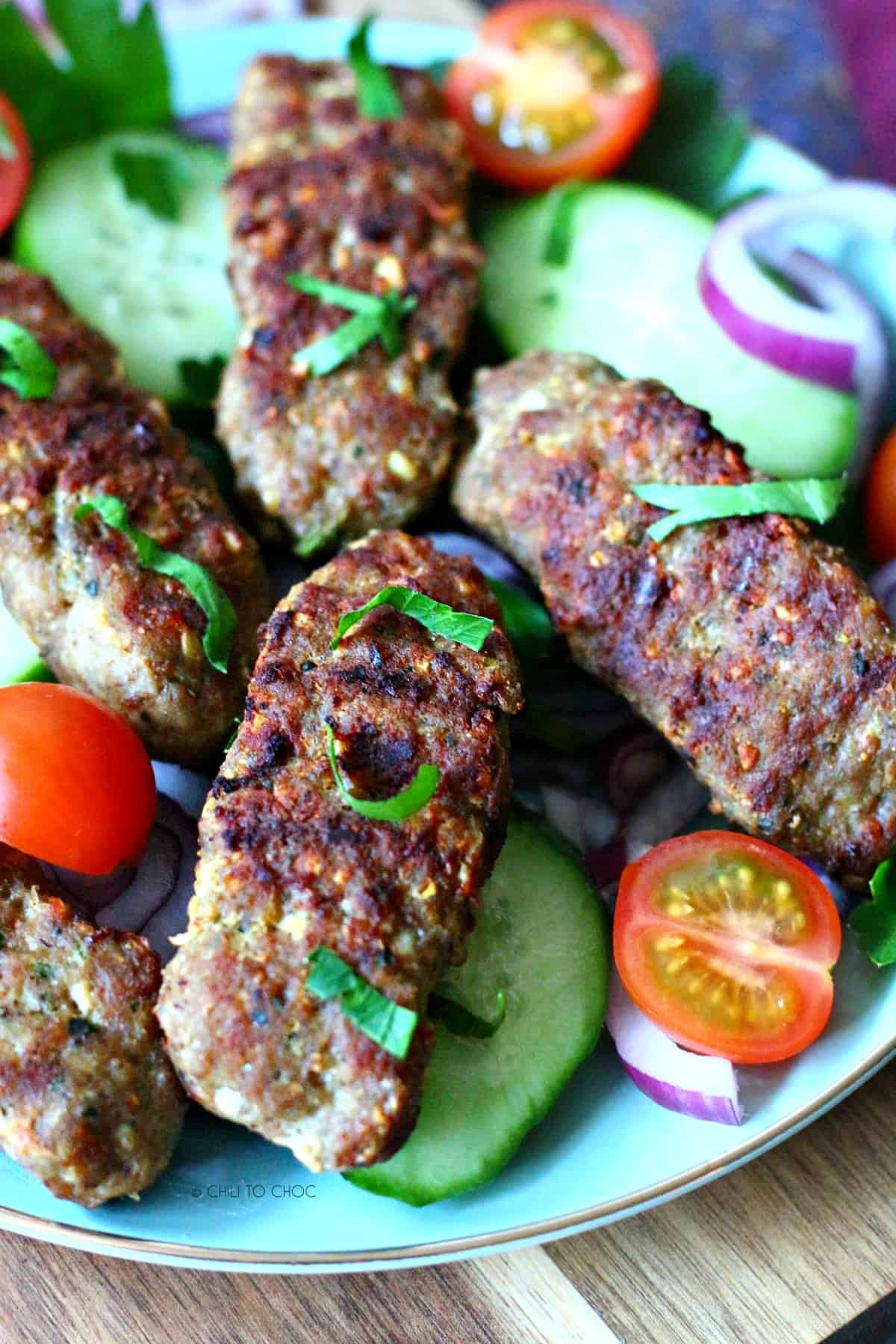 Close up of kafta kebab garnished with chopped cilantro.