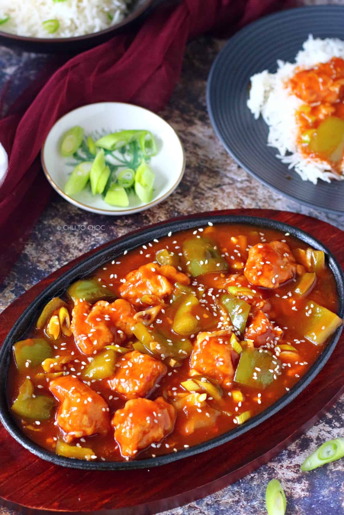 Chicken Manchurian in a sizzler platter with sesame seeds and bell pepper