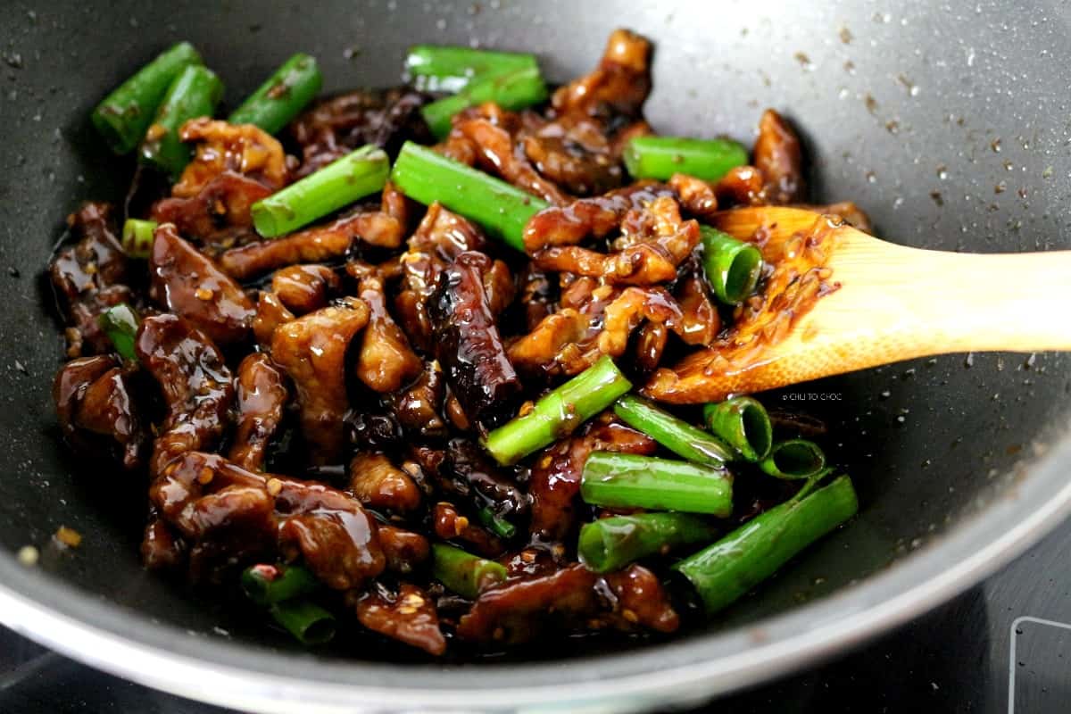 Stir fry beef and spring onions in a wok