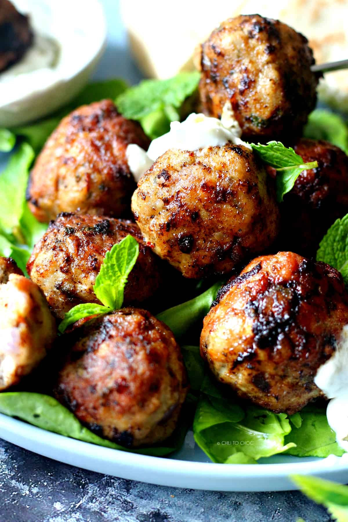 Closeup of Greek meatballs with tzatziki on it.
