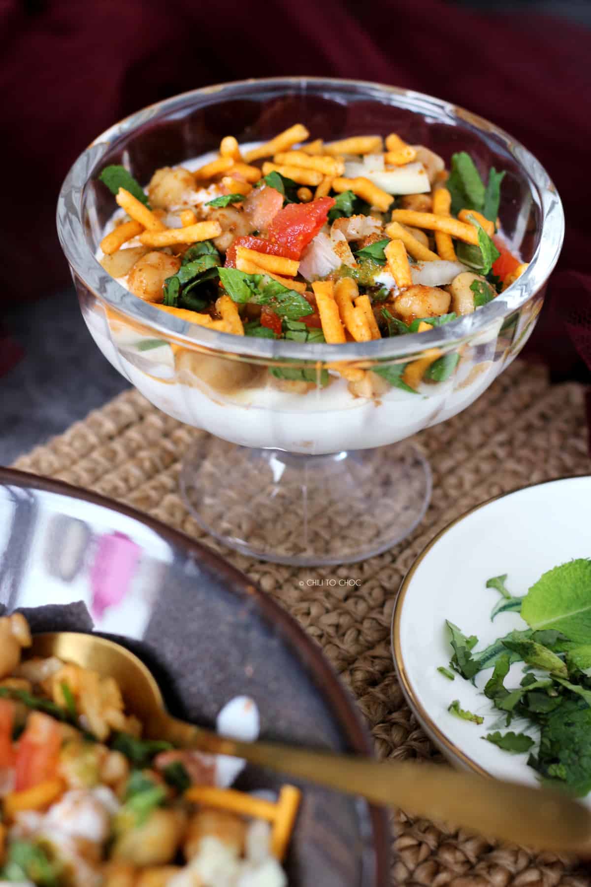 Single serving of chana chaat with garnishes on top.