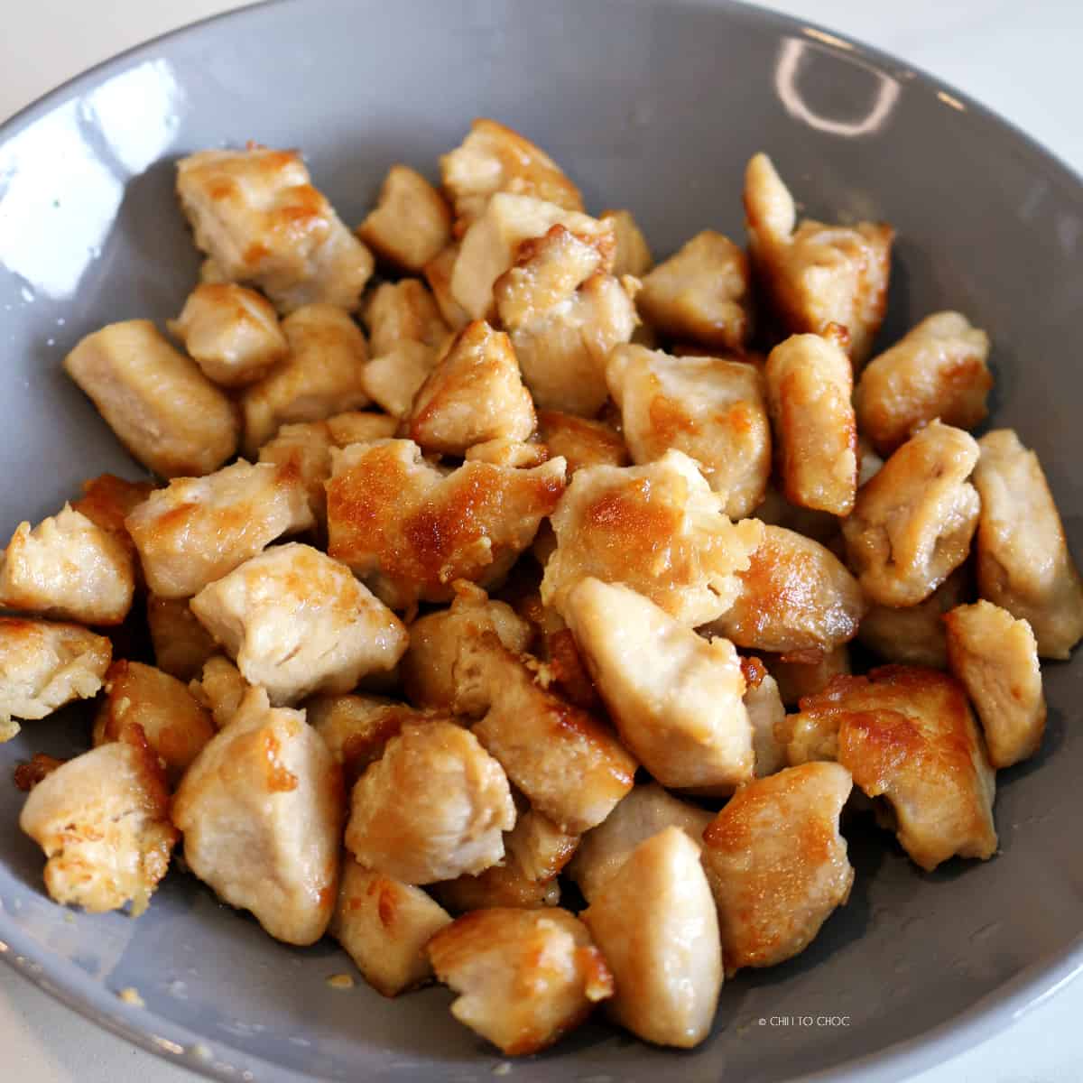 Pan-fried chunks of chicken in a shallow dish