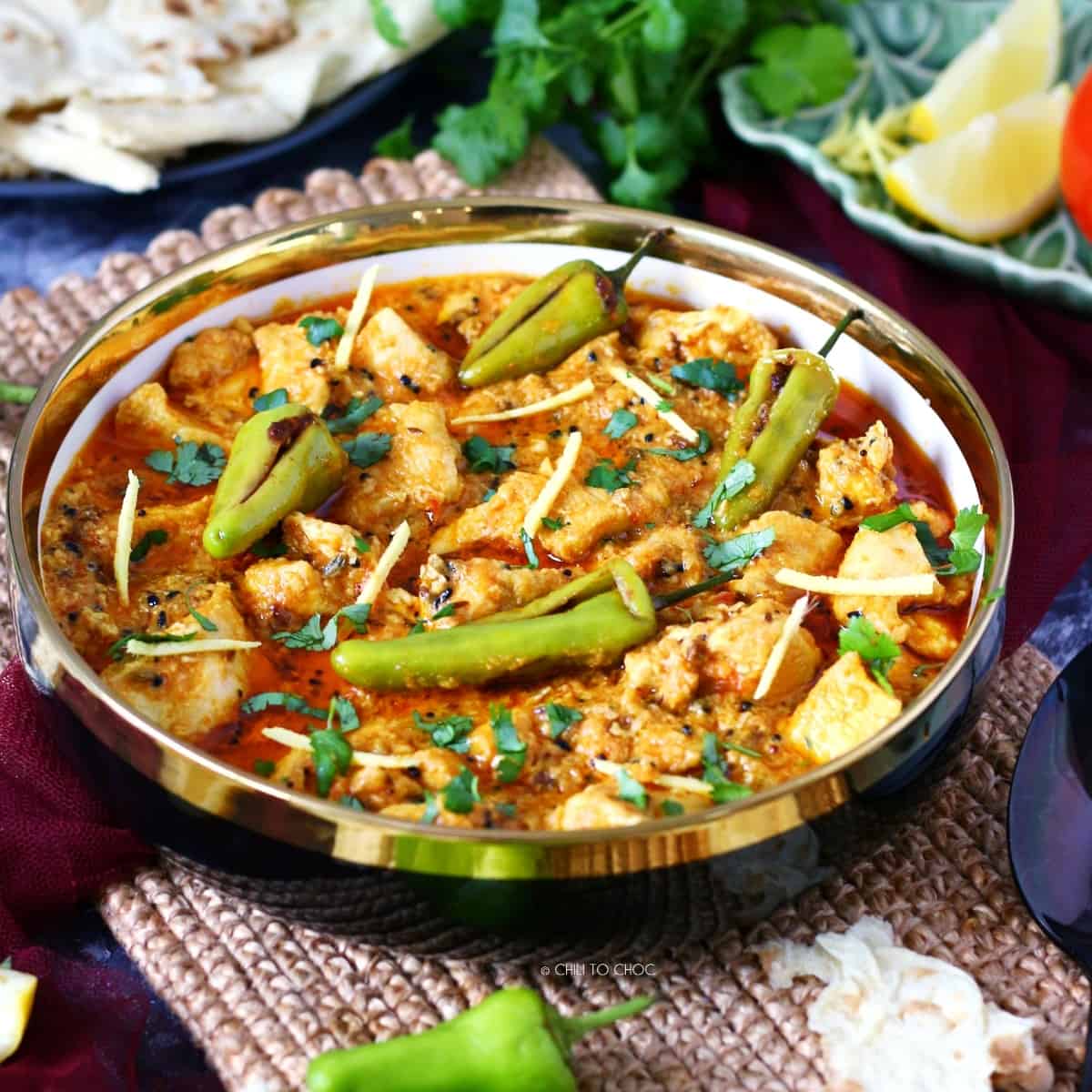 boneless achari chicken with stuffed chilies in a serving dish
