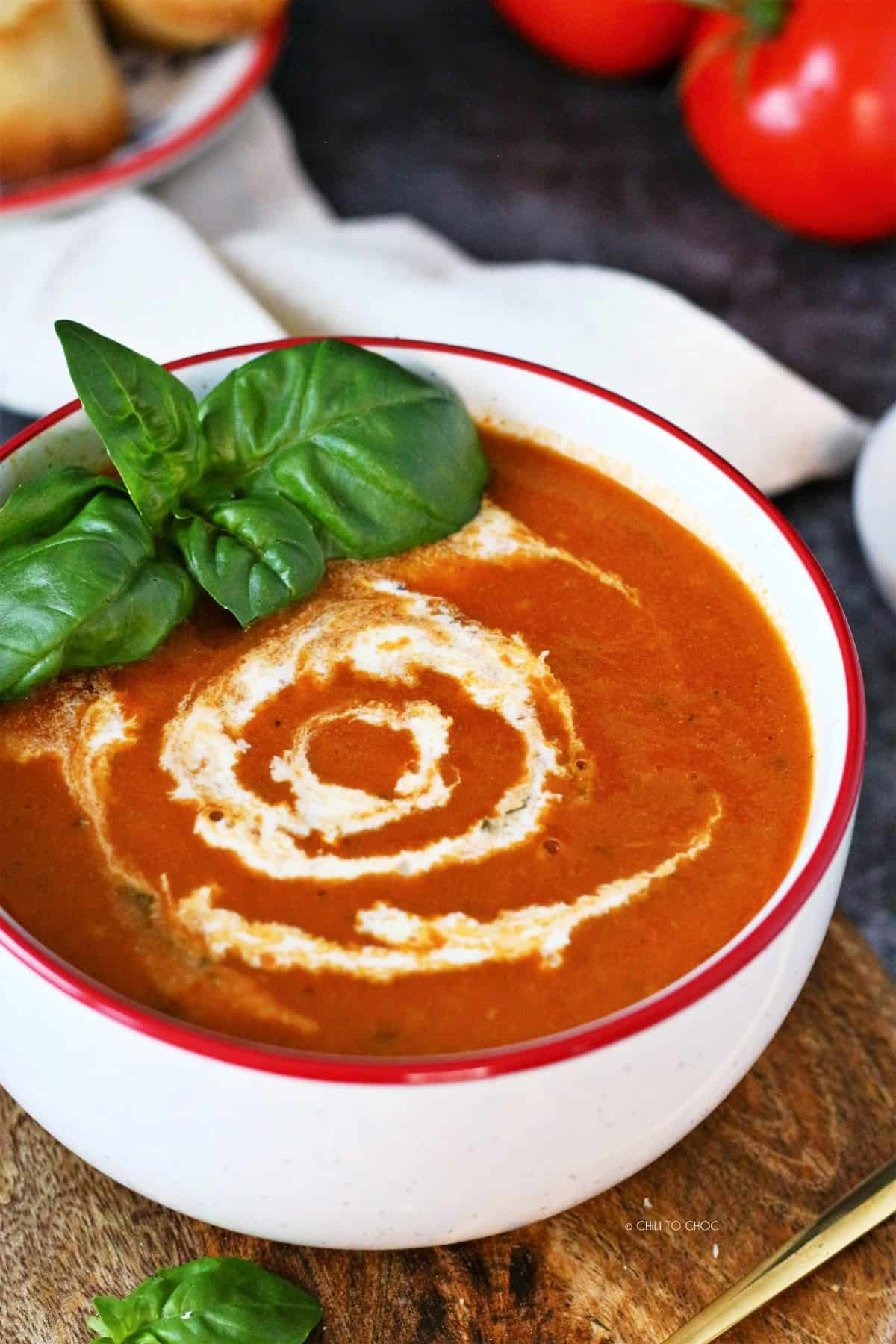 Roasted Tomato Basil Soup with cream swirls and fresh basil