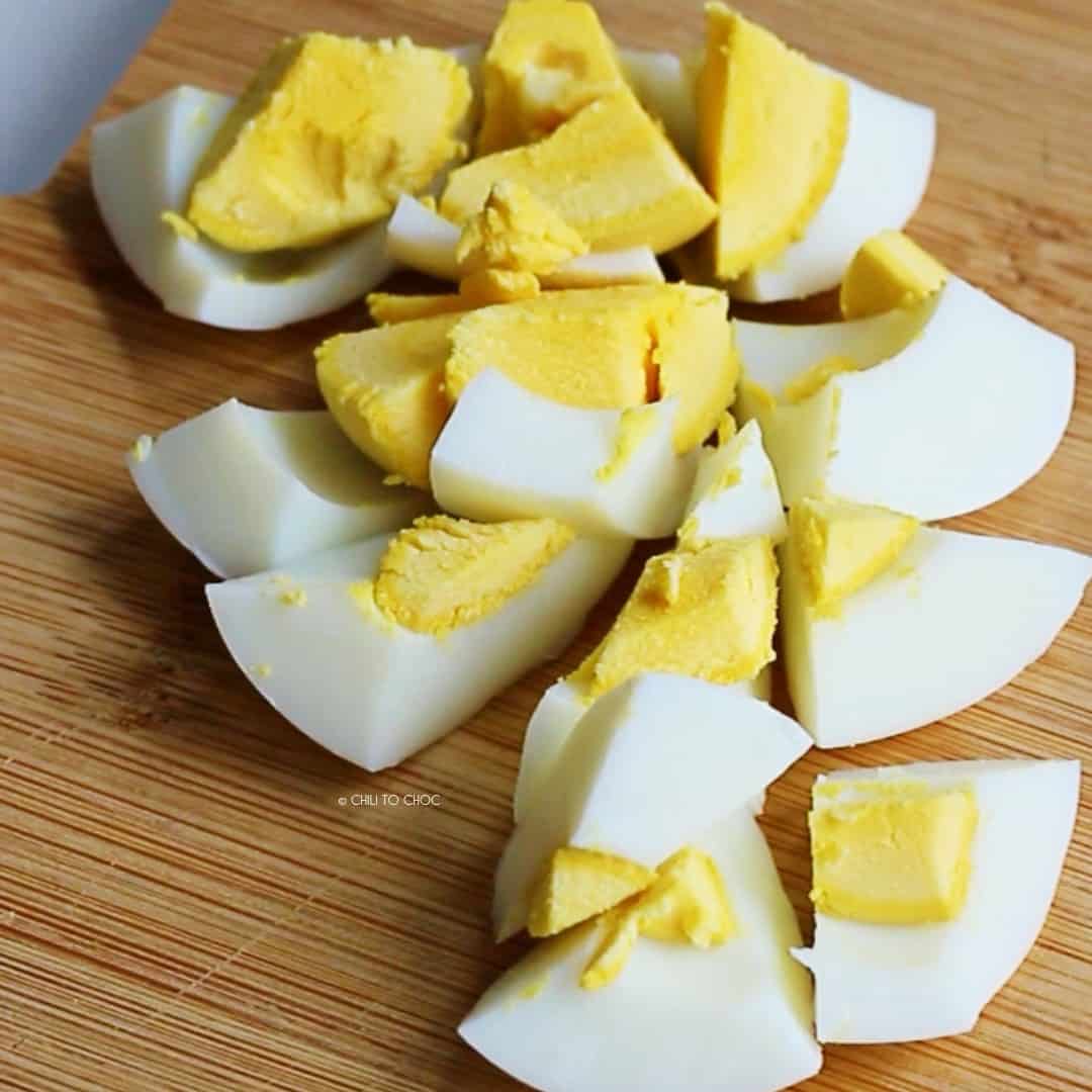 Chopped hard boiled egg on a wooden board.