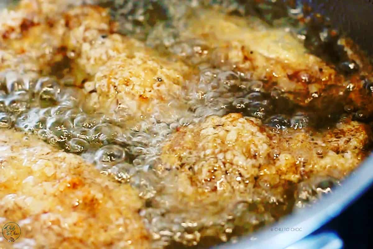 Chicken wings being deep-fried in hot oil.