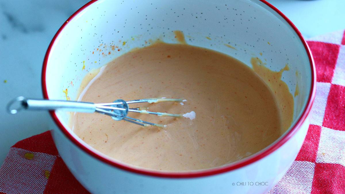 Burger sauce in a white bowl with small whisk.
