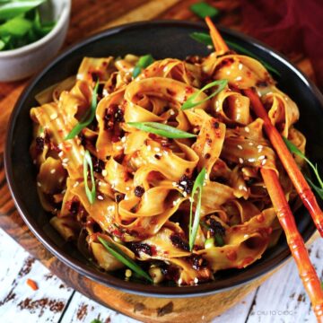 Chili oil noodles in a bowl with chopsticks.
