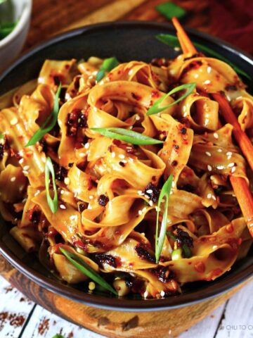 Chili oil noodles in a bowl with chopsticks.