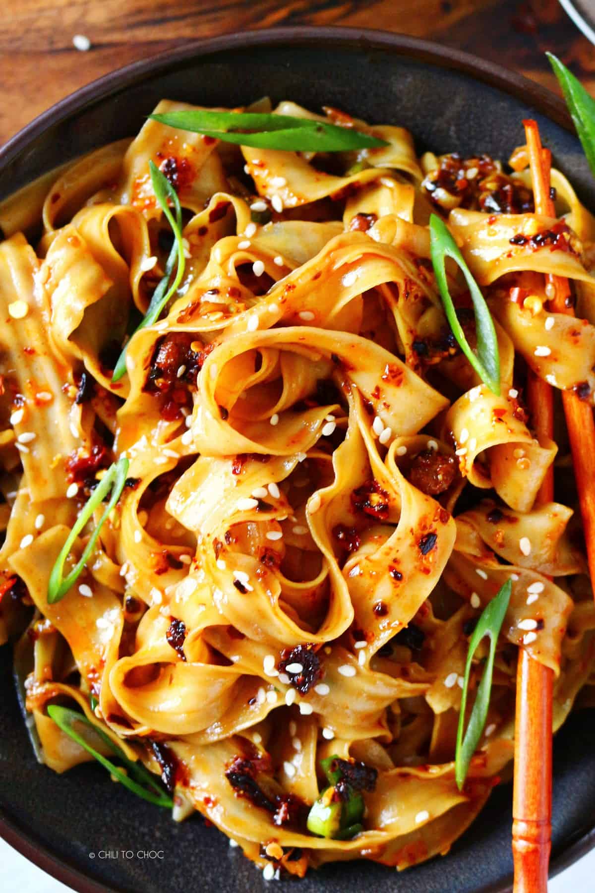 Garlic chili noodles with chopsticks intertwined.