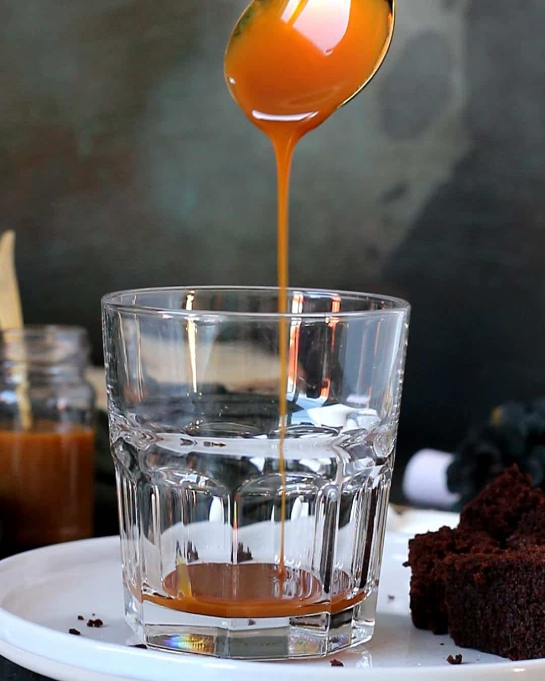 Pouring caramel sauce in a glass.