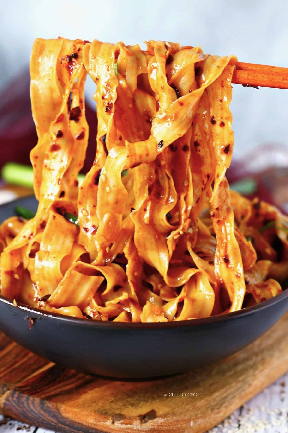 Using chopsticks to hold chili oil noodles.