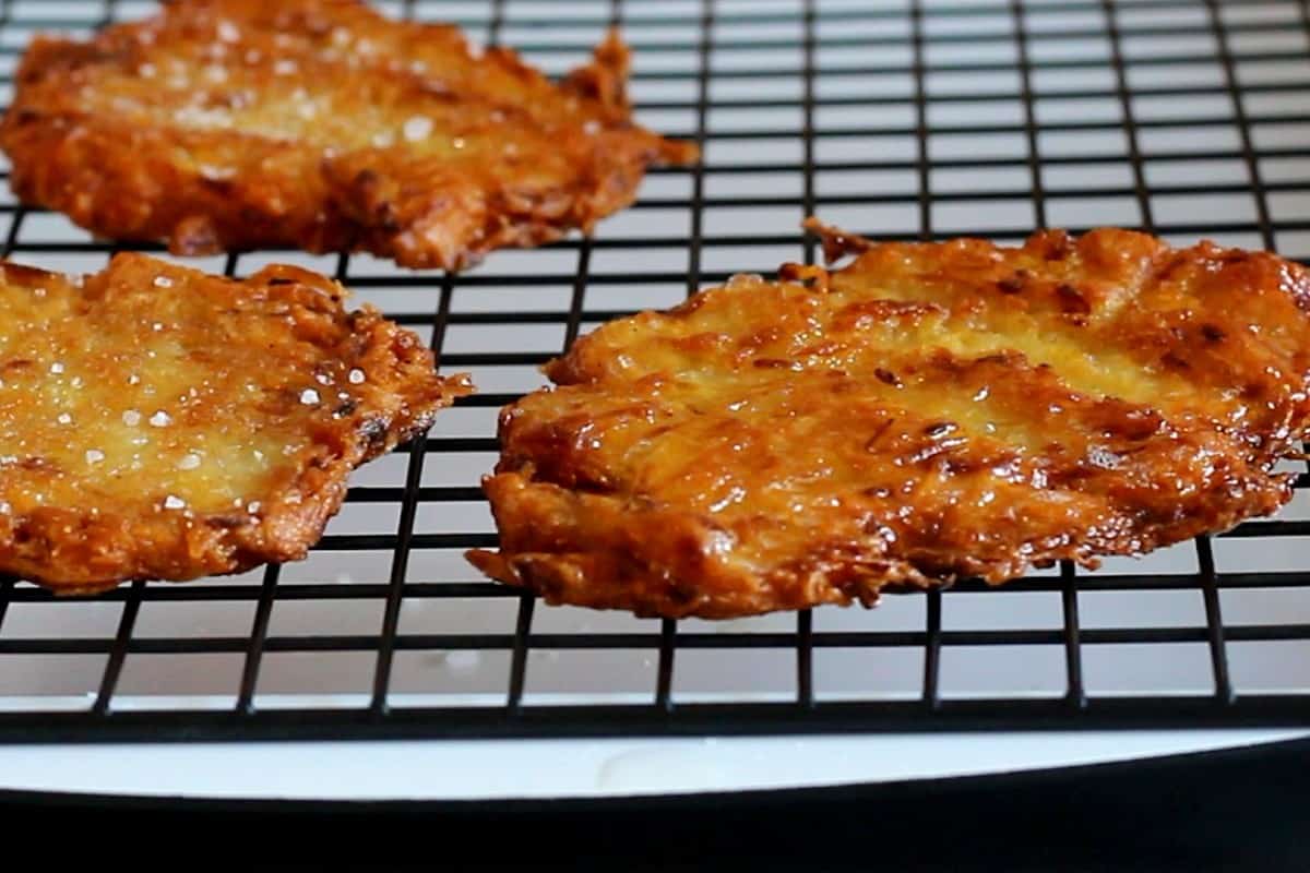 Potato pancakes laid out on a wire rack.