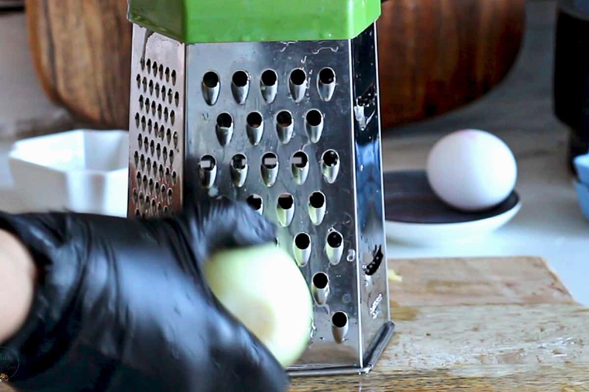 Grating an onion on a box grater.