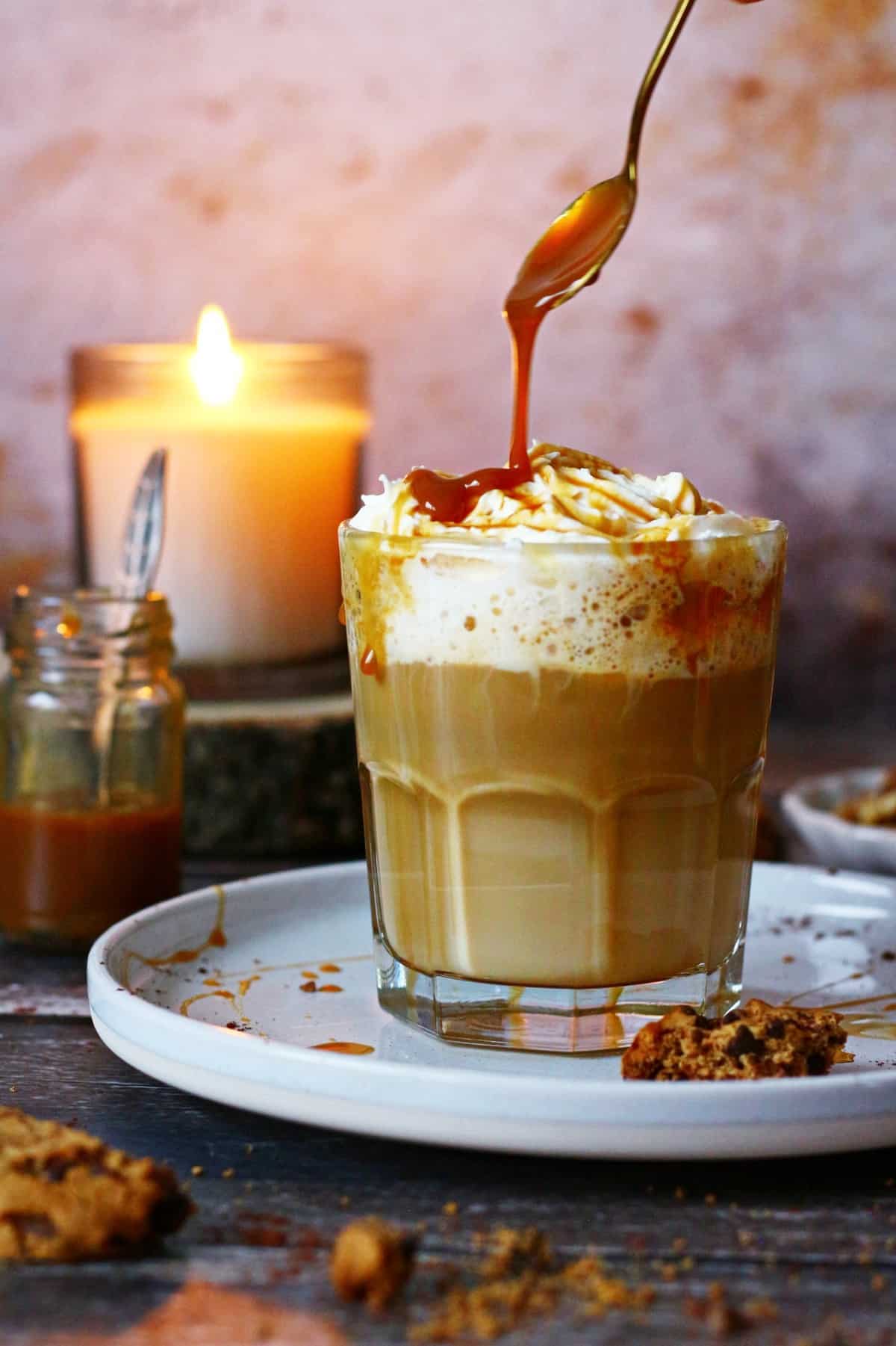 Pouring caramel sauce on the latte.