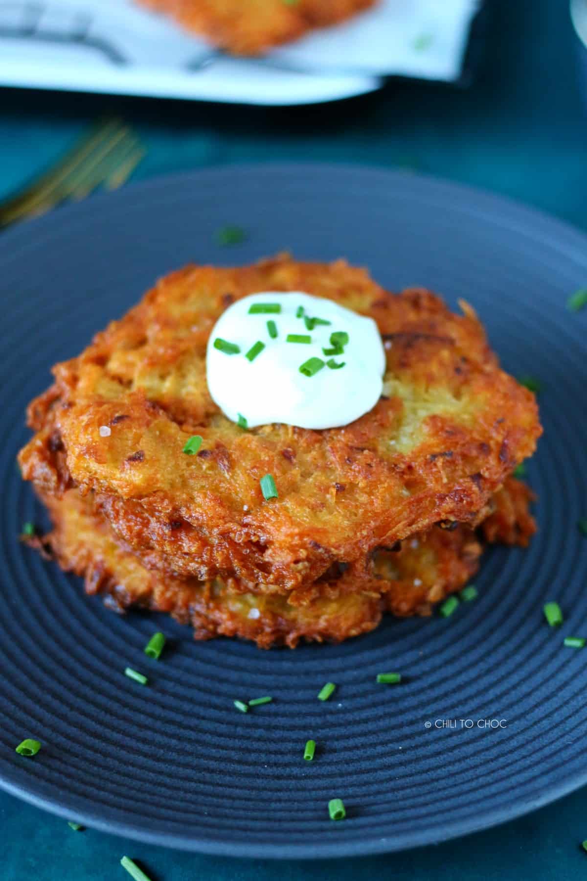 A stack of German potato pancakes served with sour cream.