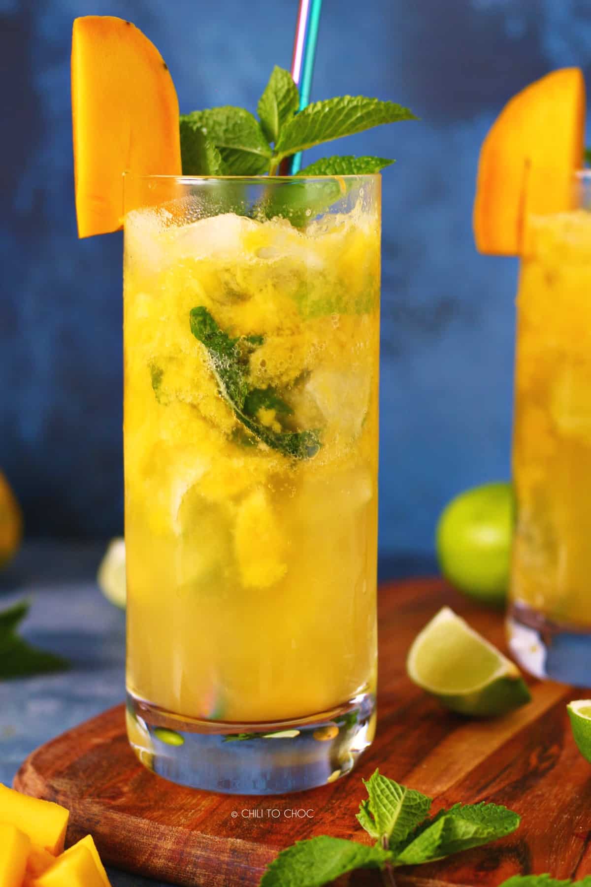 A glass of mango mojito on a wooden board.