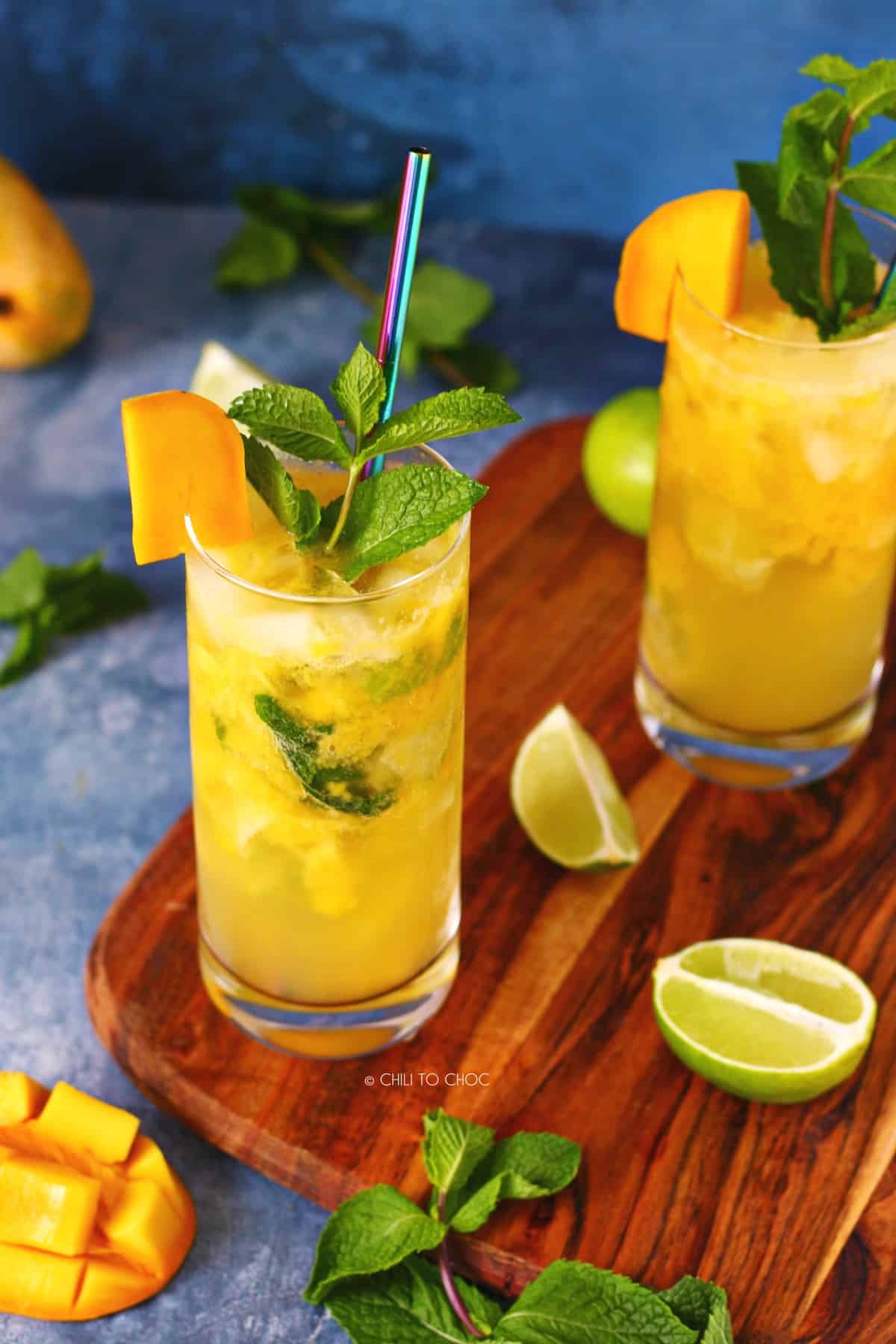 Two glasses of mango mojito by lime, mint and fresh mango.
