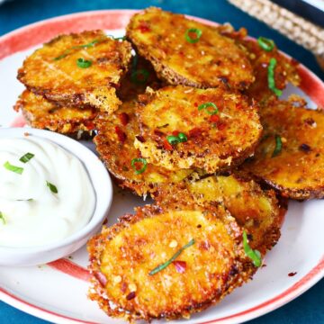Crispy Parmesan crusted potatoes on a plate with garlic aioli dip.