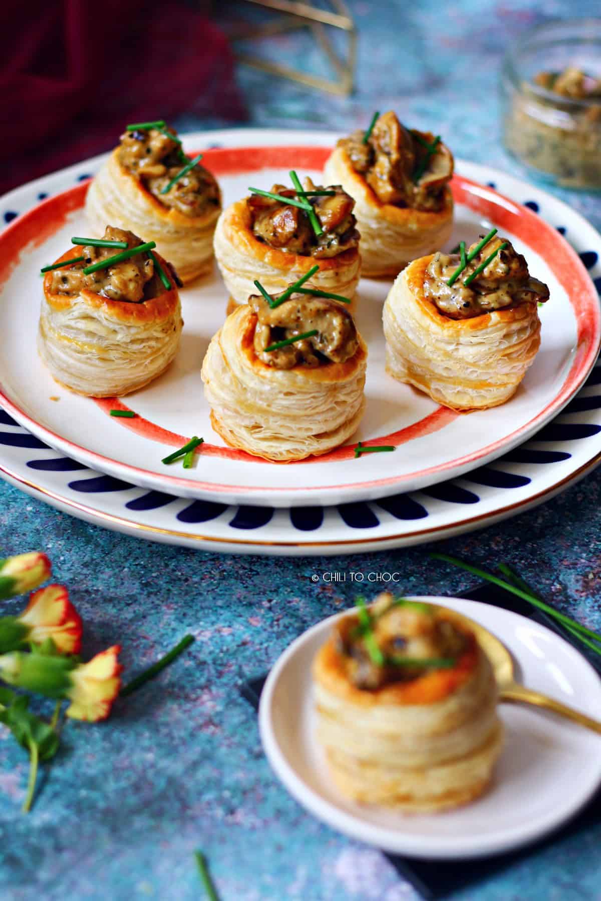 Chicken And Mushroom Vol Au Vent A group of six vol au vents on a set of plates with one vol au vent at the front.