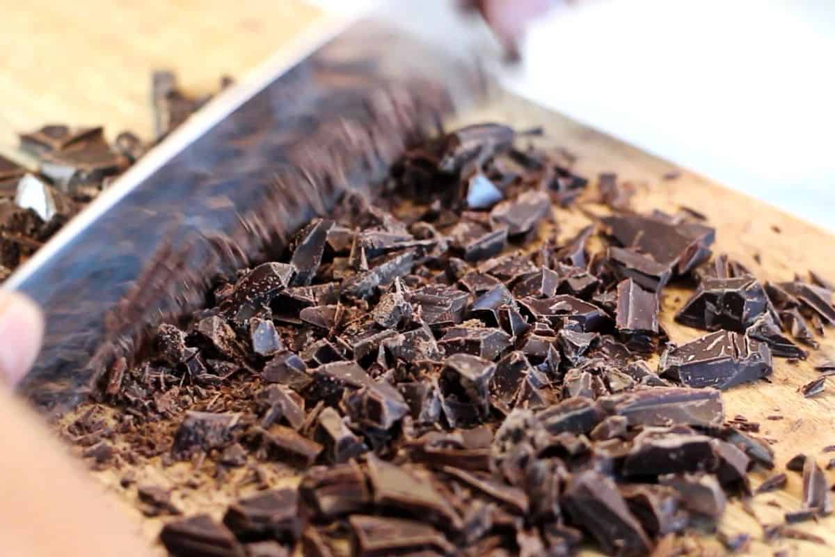 Chopping dark chocolate pieces.
