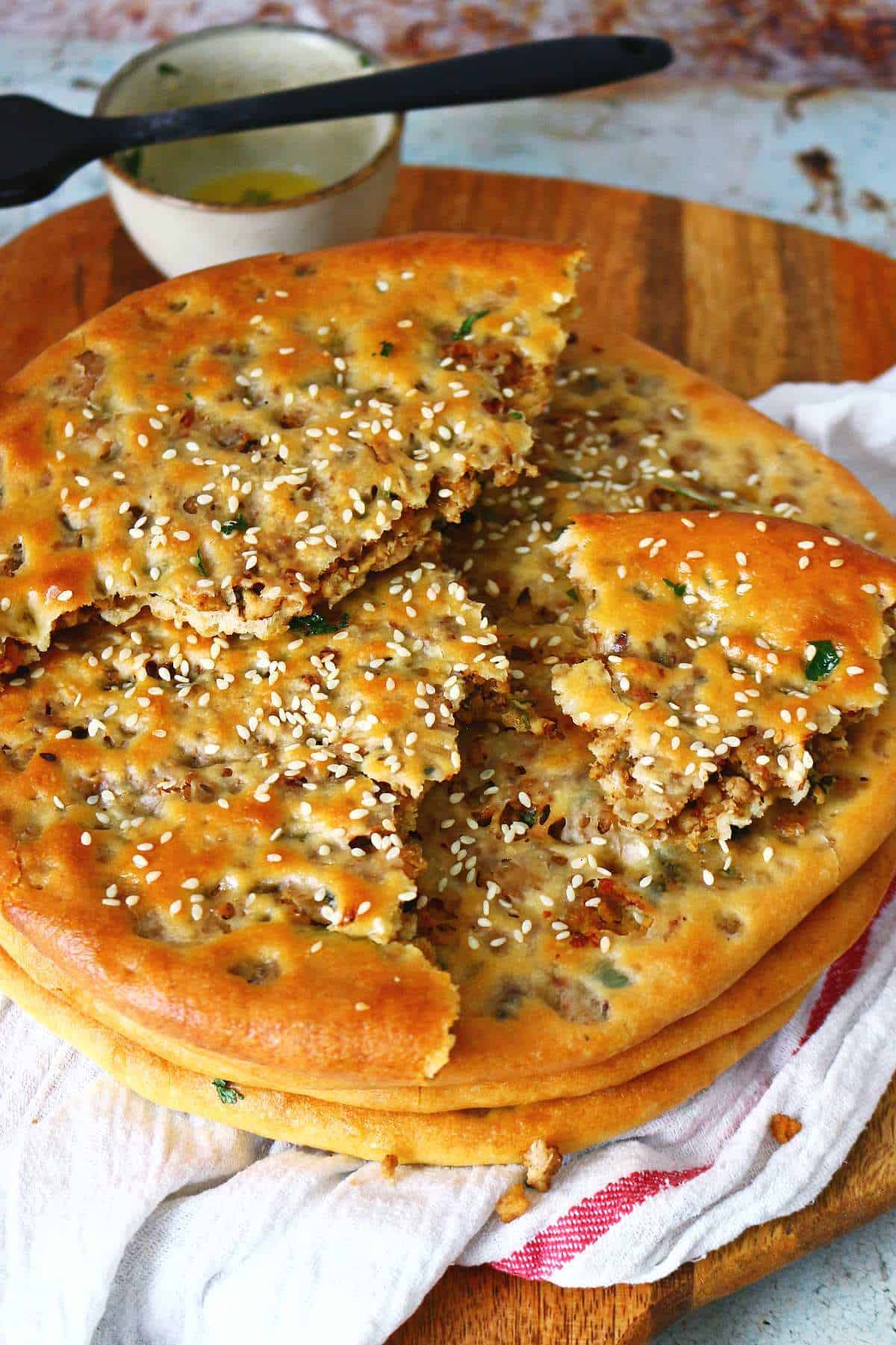 A stack of keema naans with broken pieces on top.