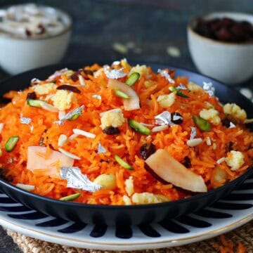 Zarda rice in serving dish garnished with nuts and dried fruits.