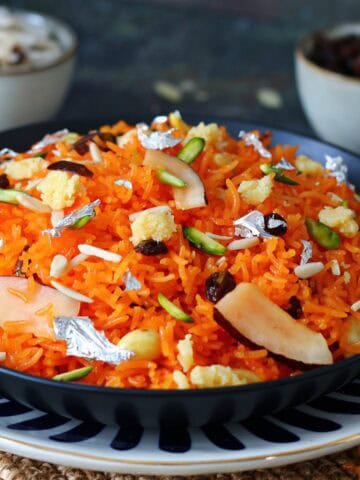 Zarda rice in serving dish garnished with nuts and dried fruits.