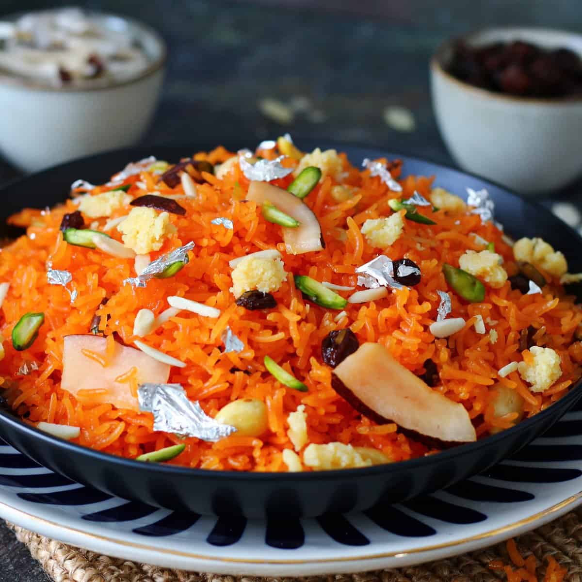 Zarda rice in serving dish garnished with nuts and dried fruits.