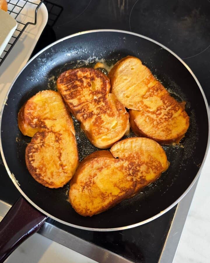 Cooking French toast in a black frying pan.