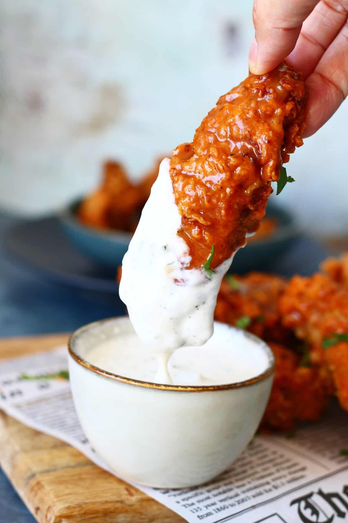 Buffalo chicken tender dripping with ranch dipping sauce.