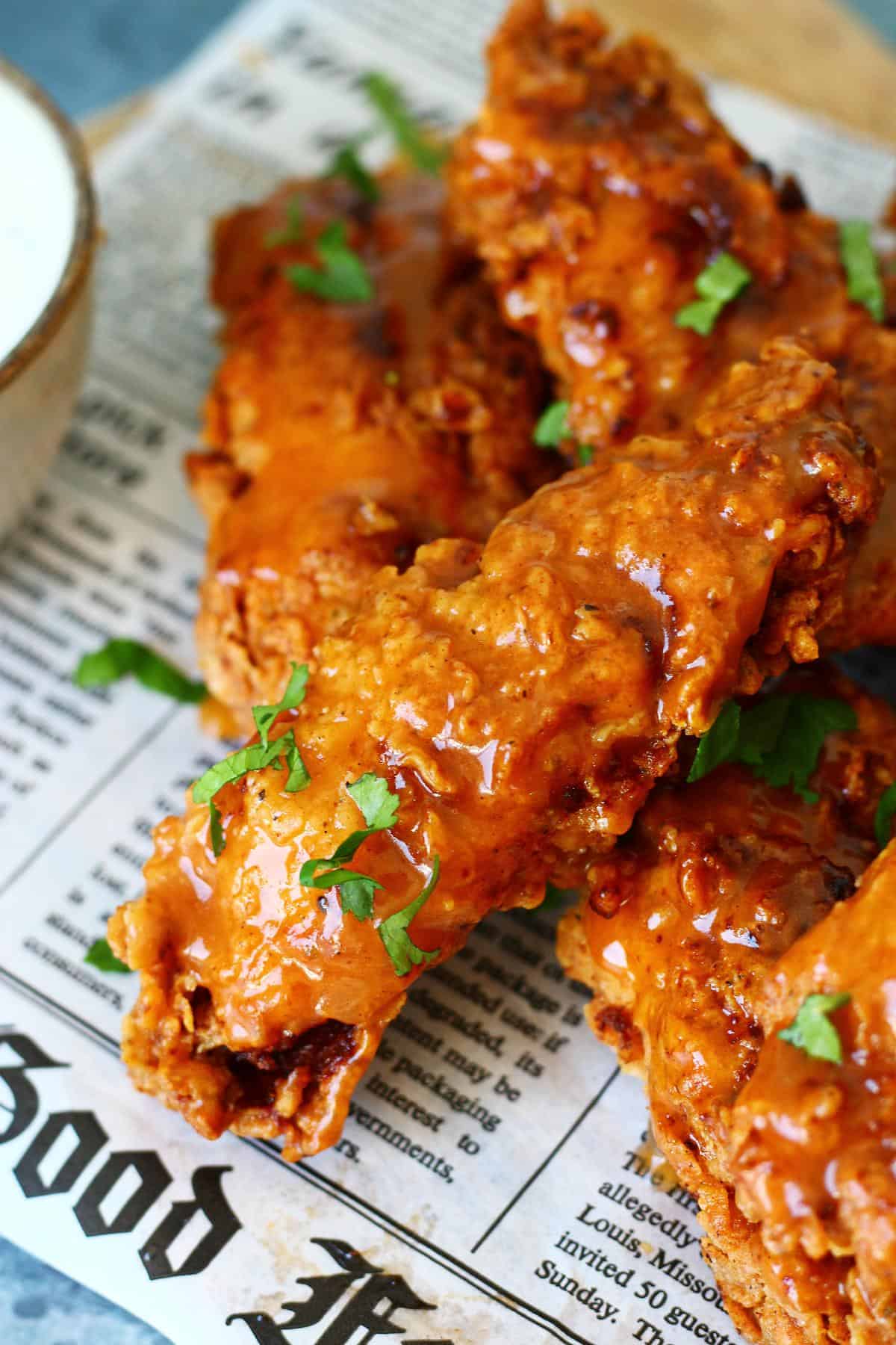 Buffalo chicken tender on a newspaper.