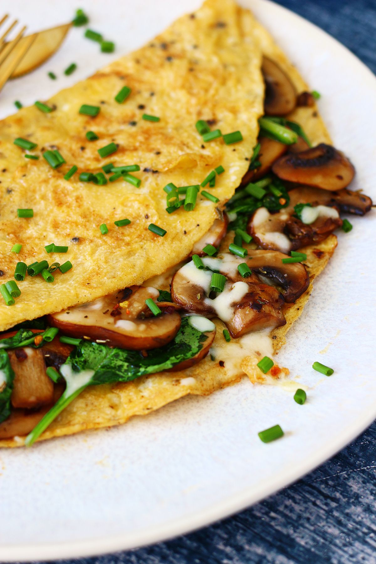 Close up of cheese stuffed spinach and mushroom omelette.