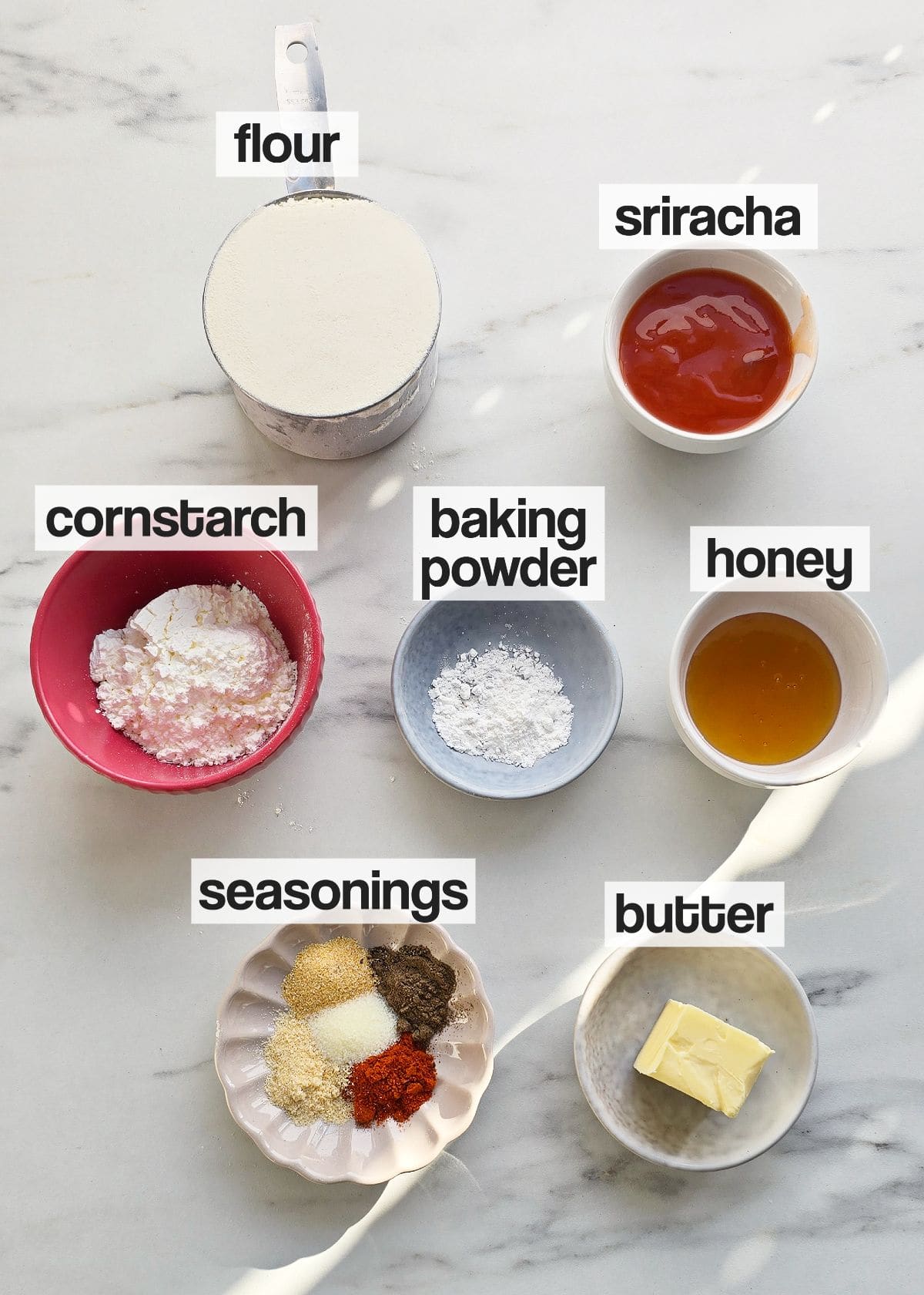 Ingredients for dredging and sauce on a marble counter.