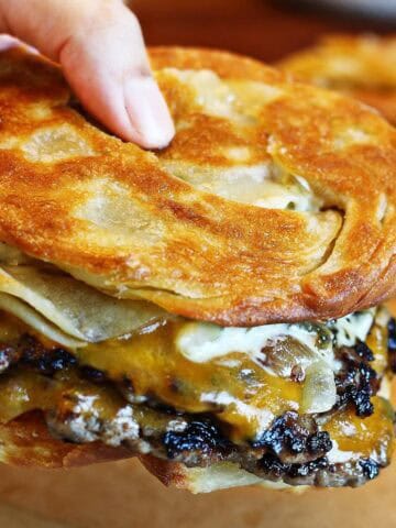 Holding a paratha smash burger.