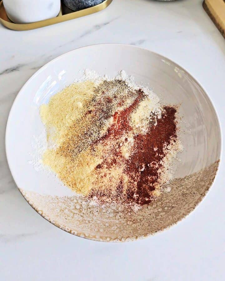 Dredging mix with seasonings in a shallow bowl.