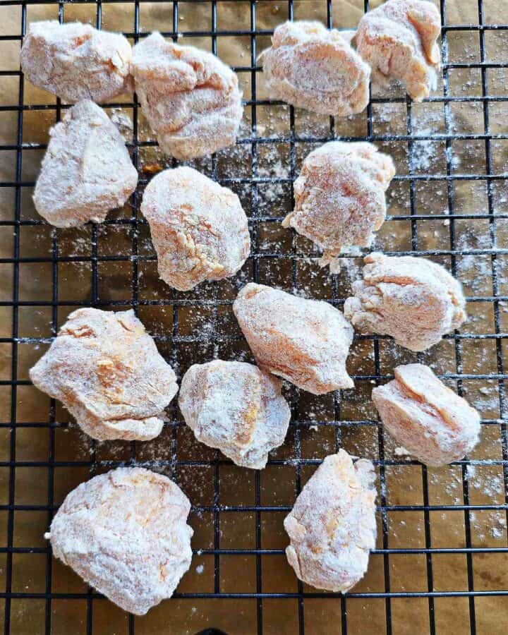 Coated pieces of chicken on a wire rack.