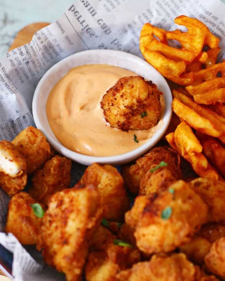 Chicken nugget dipped in sauce.