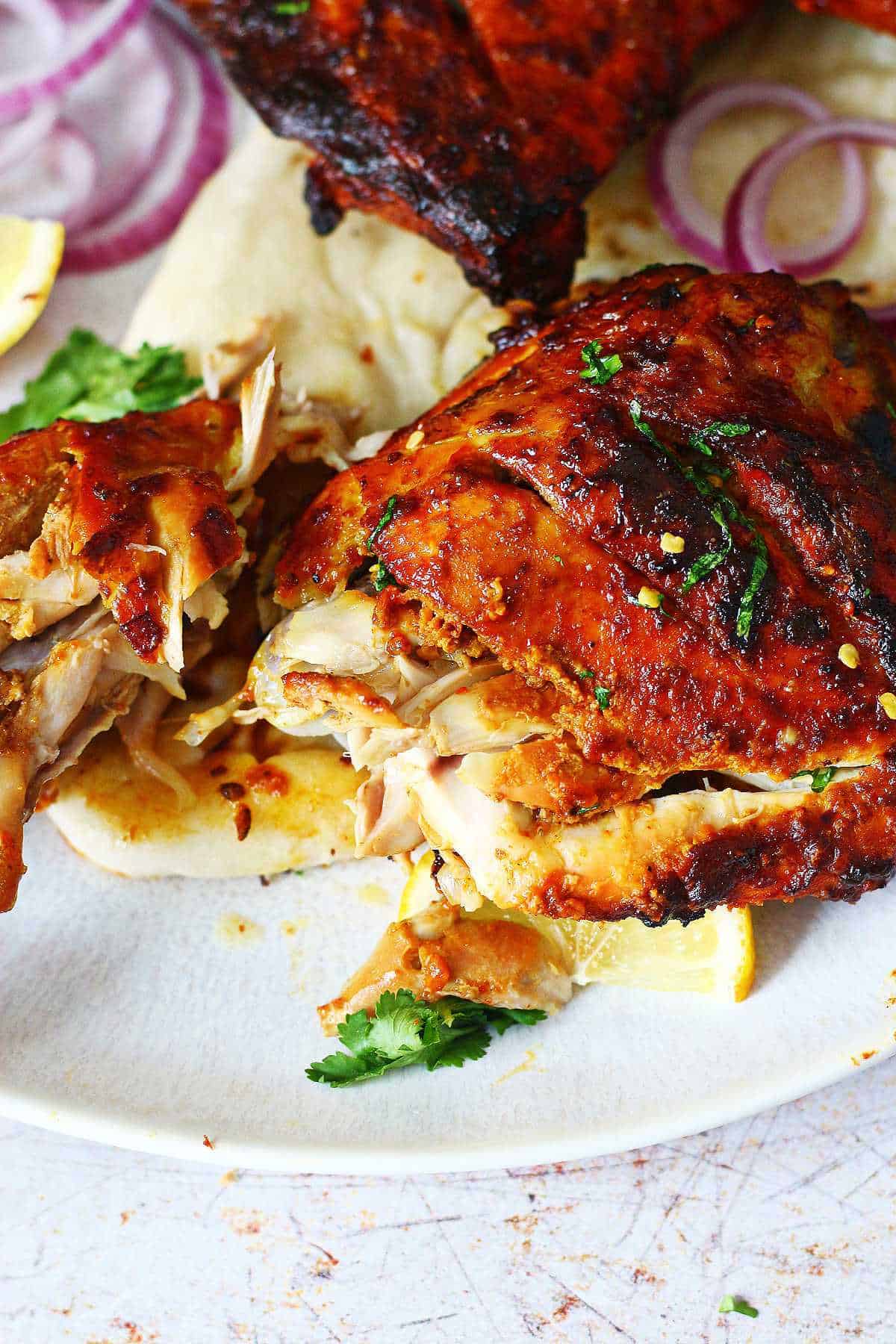 Cut up tandoori chicken quarter.