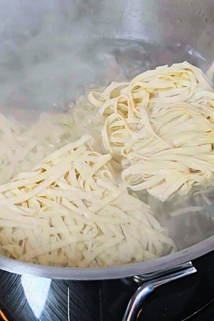 Uncooked noodles in a pot of boiling water