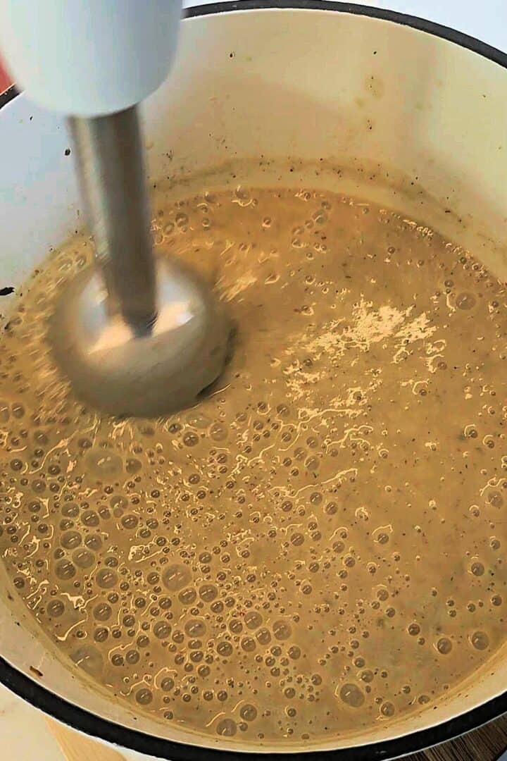 Soup being blended with an immersion blender.